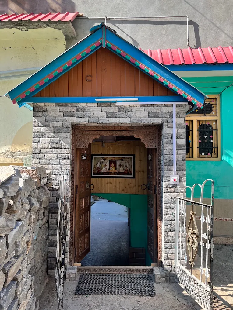 Handcrafted carved wooden entrance at Negi Cottage